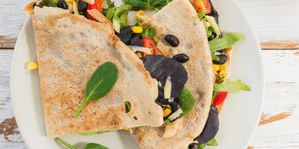 photo of 2 quesadillas filled with veggies resting on a white plate
