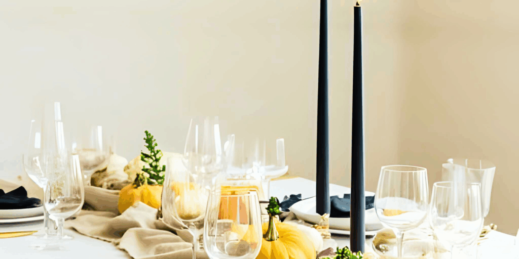 "Elegant Thanksgiving tablescape featuring cream and navy tones, adorned with candlelight and minimal floral arrangements, capturing the essence of modern holiday decor."